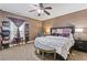 A bedroom featuring a queen bed, accent bench, ceiling fan, dark wood furniture, and a decorative display shelf at 2311 Norbury Se Cv, Smyrna, GA 30080
