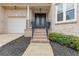 Welcoming entrance featuring an ornate double door, brick steps, and manicured landscaping, adjacent to garage at 2311 Norbury Se Cv, Smyrna, GA 30080