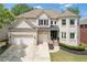 Charming two-story brick home featuring a well-manicured lawn, a two-car garage, and a welcoming entrance at 2311 Norbury Se Cv, Smyrna, GA 30080