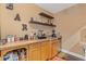 A wet bar featuring a sink, floating shelves, mini fridge, wood cabinets, and decorated with bar-themed decorations at 2311 Norbury Se Cv, Smyrna, GA 30080