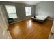 Bedroom featuring hardwood floors, two windows, and a bed with simple furnishings at 3082 Revere Ct, Atlanta, GA 30340