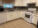Kitchen with white cabinets, tile backsplash, and white appliances at 3082 Revere Ct, Atlanta, GA 30340