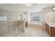 Luxurious primary bathroom with glass shower, soaking tub under window, and wood cabinets at 2100 Baywood Sw Blvd, Austell, GA 30106