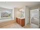 Spacious primary bath featuring a soaking tub beneath a window and a wood vanity at 2100 Baywood Sw Blvd, Austell, GA 30106