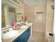 A full bathroom features ceramic tiling, dual sinks with blue vanity, toilet, shower and tub at 2176 Cold Springs Cir, Lithonia, GA 30058