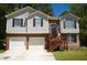 Charming two-story home featuring a brick and siding exterior, attached garage, and landscaped front yard at 2176 Cold Springs Cir, Lithonia, GA 30058