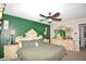 The primary bedroom with green accent wall features matching ornate dressers, lamps, mirror and ceiling fan at 2176 Cold Springs Cir, Lithonia, GA 30058