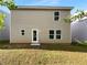 View of the flat, grassy backyard and the rear exterior of the home with a door and several windows at 325 Freeman Cir, Villa Rica, GA 30180