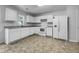 Clean kitchen featuring white cabinets, modern appliances, and durable vinyl flooring at 325 Freeman Cir, Villa Rica, GA 30180