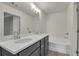 Main bathroom with double vanity, undermount sinks, tub, and modern lighting at 4142 Spring Valley Cir # 65, Tucker, GA 30084