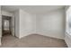 A bedroom with neutral walls and carpet, a doorway and a window overlooking the outside at 4142 Spring Valley Cir # 65, Tucker, GA 30084