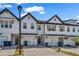 Attractive townhomes with white exteriors, garages, brick driveways, and manicured landscaping, ideal for modern living at 4142 Spring Valley Cir # 65, Tucker, GA 30084