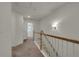 Upstairs hallway featuring neutral carpeting, railing with wood detail, and ample lighting from decorative wall sconces at 4142 Spring Valley Cir # 65, Tucker, GA 30084