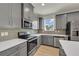 Bright kitchen with stainless steel appliances, grey cabinets, white counters, and modern backsplash at 4142 Spring Valley Cir # 65, Tucker, GA 30084