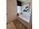 Bathroom with soaking tub, linen closet, and window with stylish blue roman shade at 1567 Aiden Way # 34, Conyers, GA 30013