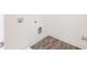 A minimalist laundry room features gray wood-look floors and white walls with utility hookups at 1567 Aiden Way # 34, Conyers, GA 30013