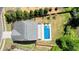 Aerial view of a private pool with a spa, located in the backyard of a gray-roofed home with lush green surroundings at 526 Lost Creek Dr, Woodstock, GA 30188