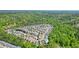 Aerial view shows a densely populated community with lush trees and a home near a playground, pond and pool at 526 Lost Creek Dr, Woodstock, GA 30188