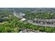 Aerial view of a community surrounded by trees with winding streets and a pond; the home has a pool and playground nearby at 526 Lost Creek Dr, Woodstock, GA 30188