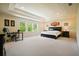 Expansive bedroom with tray ceiling, large windows, and modern furnishings with a designated desk and seating area at 526 Lost Creek Dr, Woodstock, GA 30188