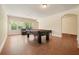 Spacious game room features a pool table, wood floors, and large windows overlooking the lush landscape at 526 Lost Creek Dr, Woodstock, GA 30188