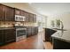 A kitchen with dark cabinets, stainless steel appliances, granite countertops, and hardwood flooring at 526 Lost Creek Dr, Woodstock, GA 30188
