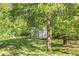 Picturesque backyard featuring a storage building and mature trees that provide ample shade and privacy at 560 Austin Dr, Mcdonough, GA 30252