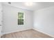 A sunny bedroom with a bright window, light gray walls, and modern wood flooring at 560 Austin Dr, Mcdonough, GA 30252