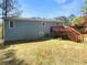 Backyard view of home featuring a wooden deck with stairs leading to a lush green lawn at 5790 Ivywood Dr, Lithonia, GA 30038