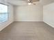 Bright bedroom offers ample space, a ceiling fan, and natural light from the large window at 5790 Ivywood Dr, Lithonia, GA 30038