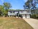 Charming two-story home featuring a well-maintained lawn and two-car garage, under a clear blue sky at 5790 Ivywood Dr, Lithonia, GA 30038