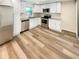 Well-lit kitchen features white cabinets, stainless steel appliances, and wood-look flooring for modern living at 5790 Ivywood Dr, Lithonia, GA 30038
