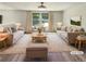 Bright living room features neutral furniture, wood-look flooring, and large windows for plenty of natural light at 5790 Ivywood Dr, Lithonia, GA 30038
