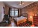 Bedroom with exposed brick wall, hardwood floors, and a window with natural light at 741 Frederica Ne St # 8, Atlanta, GA 30306