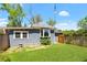 A cozy backyard featuring green grass, privacy fence, and charming architectural details on the home's exterior at 873 United Se Ave, Atlanta, GA 30312