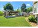 Lush backyard with a covered pergola, green lawn, string lights, and privacy fence at 873 United Se Ave, Atlanta, GA 30312