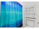 Bright bathroom featuring a toilet, a storage cabinet, and a blue and green shower curtain at 873 United Se Ave, Atlanta, GA 30312