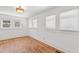 Bright bedroom with hardwood floors, white walls, a modern light fixture, and three windows at 873 United Se Ave, Atlanta, GA 30312