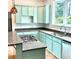 Well-lit kitchen showcasing mint cabinets, granite countertops, stainless steel appliances, and a view of the backyard at 873 United Se Ave, Atlanta, GA 30312