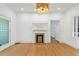 Bright living room features refinished hardwood floors, fresh white paint, a fireplace, and a modern light fixture at 873 United Se Ave, Atlanta, GA 30312