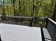 Back deck with grey wood, and grey painted railing, surrounded by a forest with green leaves at 225 Austin Oaks Se Dr, Ellenwood, GA 30294