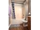 Bathroom featuring a vanity, toilet and tub with shower, wood laminate flooring and neutral colored walls at 225 Austin Oaks Se Dr, Ellenwood, GA 30294