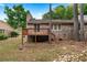Back exterior view of house with wooden deck, surrounded by mature trees and a peaceful creek at 2404 Northlake Ct, Atlanta, GA 30345