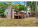 Back exterior view of the house with a wooden deck, surrounded by mature trees and landscaping at 2404 Northlake Ct, Atlanta, GA 30345