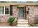 Close-up of the front entrance with brick facade, a storm door, and hanging plants at 2404 Northlake Ct, Atlanta, GA 30345