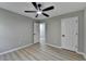 Bedroom with ceiling fan, grey walls, light hardwood floors and open doorway at 5825 Rolling Oaks Dr, Cumming, GA 30040