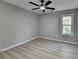 Bedroom with ceiling fan, grey walls, light hardwood floors and window at 5825 Rolling Oaks Dr, Cumming, GA 30040