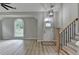 Bright foyer with wood stairs, luxury vinyl plank flooring and decorative chandelier at 5825 Rolling Oaks Dr, Cumming, GA 30040