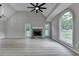 Open living room with vaulted ceiling, stone fireplace, large picture window and fan at 5825 Rolling Oaks Dr, Cumming, GA 30040