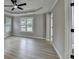 Large main bedroom featuring tray ceilings, hardwood floors, and a ceiling fan at 5825 Rolling Oaks Dr, Cumming, GA 30040